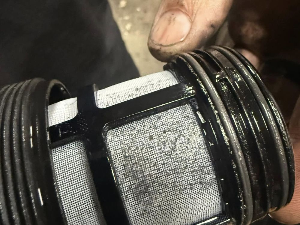 Mechanic inspecting a used filter element during truck maintenance